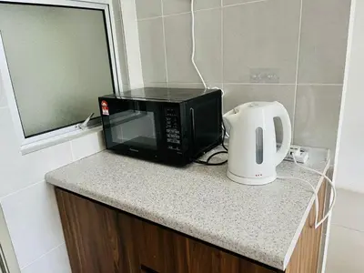 a microwave sitting on top of a counter with a toaster at 1 Bedroom Apartment @ Golden Hills Cameron Highlands Pasar Malam in Cameron Highlands
