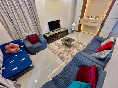 a living room with two blue couches and a tv at Comfort 36 Entire House At Alma Bukit Mertajam in Bukit Mertajam