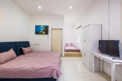 a bedroom with a bed and a desk with a television at Seaside Private Bungalow, Tg Bungah in Tanjung Bungah