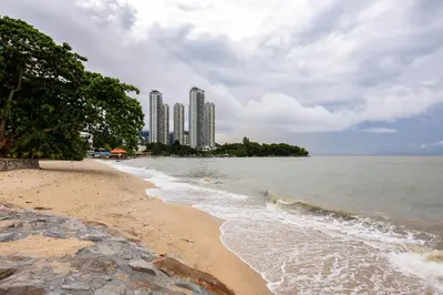 a sandy beach with tall buildings in the background at Seaside Private Bungalow, Tg Bungah in Tanjung Bungah