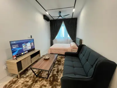a living room with a couch and a tv and a bed at Cozy Suite Studio Meritus Residensi Perai in Perai
