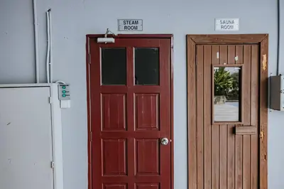 a red door and a wooden door next to a refrigerator at Ipoh Town Apartment 8pax by Cozy in Ipoh