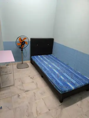 a bed in a room with a fan at Rent Room in Ipoh