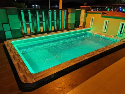 a swimming pool at night in a house at HOMESTAY EPOH MANJOI WITH PRIVATE POOL AND JACUZZI in Ipoh