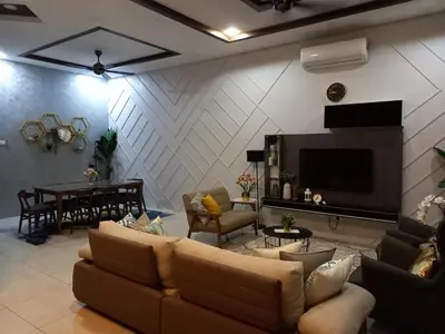 a living room with couches and a television and a table at RS Homestay in Sungai Petani