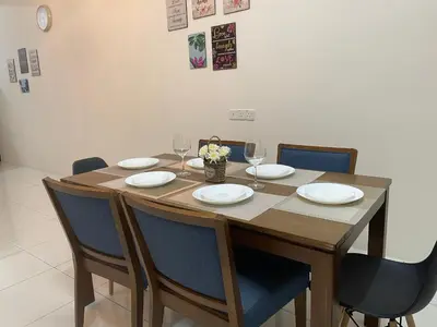 a wooden table with chairs and plates and wine glasses at ZaraVip homestay in Lahat