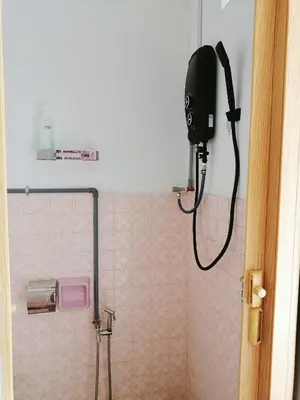 a bathroom with a shower with a blow dryer on the wall at Destiny Homestay in Sungai Petani