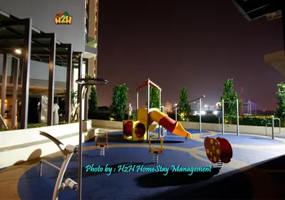 a playground with a slide in a city at night at H2H - CosyStay @ Majestic Ipoh Town Central in Ipoh