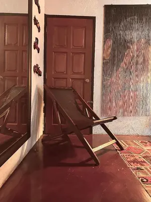 a wooden chair sitting in front of a door at The White Horse in Cameron Highlands