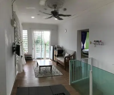 a living room with a ceiling fan and a table at Bendang Homes - Sekinchan Homestay in Kampong Sungai Leman