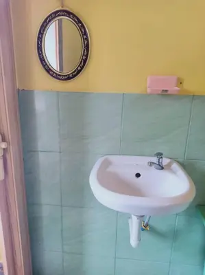 a bathroom with a sink and a mirror on the wall at Inap Desa 2 in Baling
