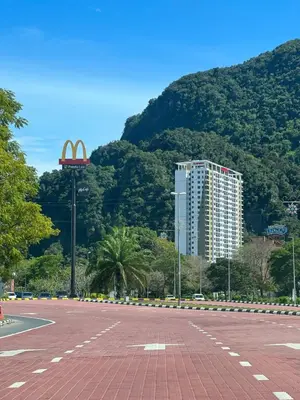 a parking lot with a mcdonalds sign and a mountain at Ipoh Peaceful Onsen studio Lost World Tambun in Tambun