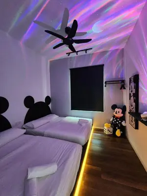 a bedroom with two beds and a ceiling with purple lights at JOMSTAY Sunway Onsen Suites Ipoh - Lost World of Tambun Ipoh Waterpark in Tambun