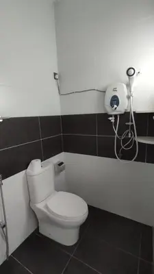 a bathroom with a toilet and a phone on the wall at Gopeng Serumah Holiday House in Gopeng