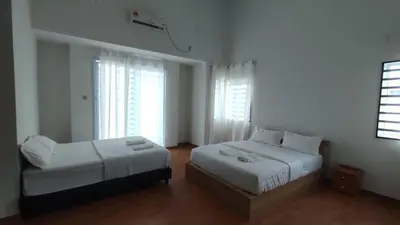a bedroom with two beds and two windows at Gopeng Serumah Holiday House in Gopeng