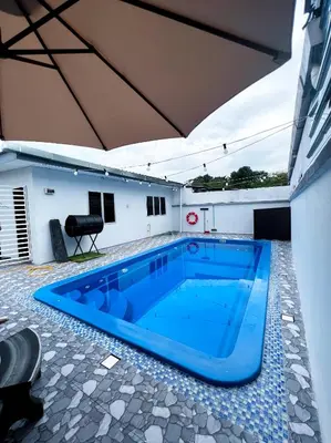 a large blue swimming pool in the middle of a building at Roomah Istana in Ipoh