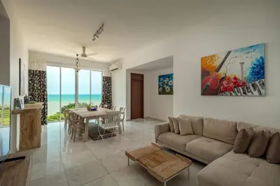 a living room with a couch and a table at Panoramic Seaview Holiday Home - Batu Ferringhi in Batu Ferringhi
