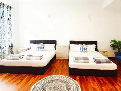 two beds in a room with wood flooring at Ocean 27 Batu Ferringhi Shamrock Beach 6 Bedroom 22pax with Pool in Batu Ferringhi