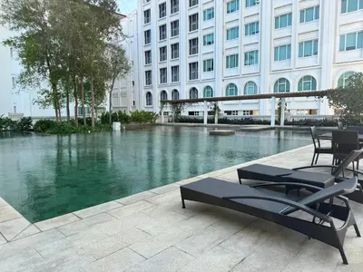 a pool of water in front of a building at Lucky Waterfront at Straits Quay Seaview or Non in Bagan Jermal