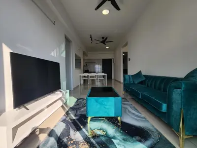 a living room with a green couch and a large tv at Praicon Tower - Premium Suite in Butterworth