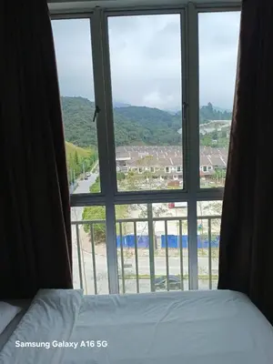 a bedroom with a large window looking out at a beach at Salena Somersquare Goldenhills Tanah Rata(Pasar Malam) in Brinchang
