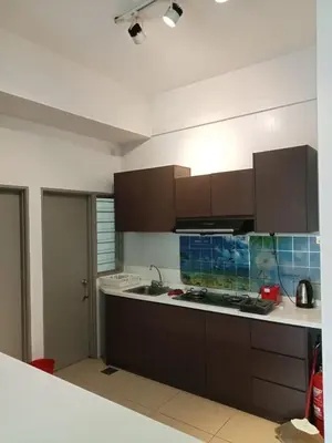 a kitchen with brown cabinets and a counter top at Salena Somersquare Goldenhills Tanah Rata(Pasar Malam) in Brinchang