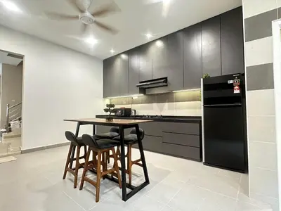a kitchen with a table and a black refrigerator at \u300aUntitled HomeStay\u300bSitiawan in Sitiawan
