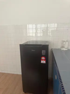 a small black refrigerator sitting in a room at Jenny Homestay in Teluk Intan