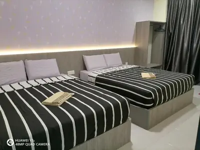 two beds sitting next to each other in a room at stoberi cekelat homestay in Brinchang