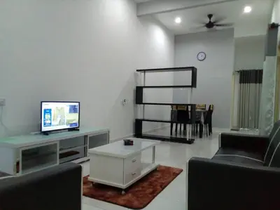 a living room with a tv and a couch and a table at Percutian Di Taiping & Bukit Merah Laketown in Kamunting