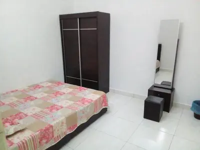 a bedroom with a bed and a dresser and a mirror at Percutian Di Taiping & Bukit Merah Laketown in Kamunting