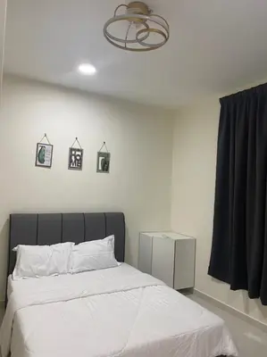 a bedroom with a large bed with white sheets at Trails of Kampar in Kampar