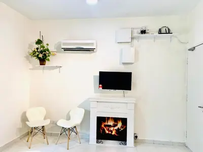 a living room with a fireplace and a tv on a wall at Trails of Kampar in Kampar