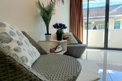 a living room with a wicker chair and a large window at Ipoh Meru Landed Semi D with Barbeque for 12 Pax in Ipoh