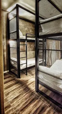 a room with three bunk beds and a wooden floor at IPOH AGONG HOMESTAY by ONE LIFE FOUR SEASON GUESTHOUSE in Ipoh