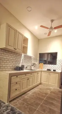 a kitchen with white cabinets and a ceiling fan at IPOH AGONG HOMESTAY by ONE LIFE FOUR SEASON GUESTHOUSE in Ipoh