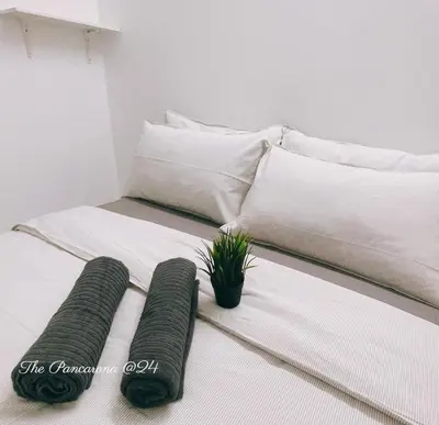 a bed with two pillows and a potted plant on it at The Pancarona24 Homestay forMuslim in Ipoh