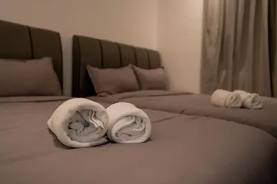 two rolls of towels sitting on a bed at Ipoh Tambun Lost World Sunway Onsen Suite 2R 8Pax Mira Theme Park View in Ipoh