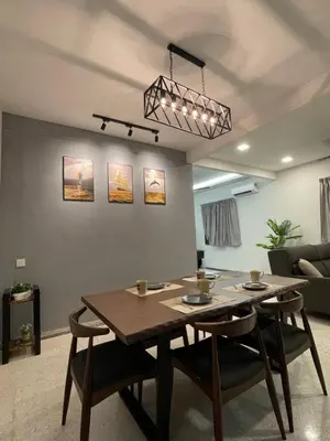 a dining room table and chairs in a living room at NEW 20PX 5BR V KTV & JACUZZI SPA & POOL TABLE at TOWN CENTER & USM - kids pool no more in Gelugor
