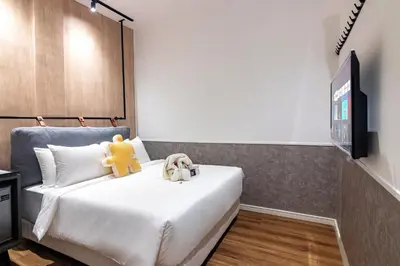 a bedroom with a bed with a teddy bear on it at Bagan Suite in Butterworth