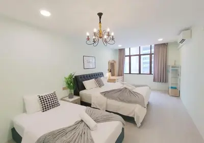 a bedroom with two beds and a chandelier at Dim Sum Homestay in Ipoh