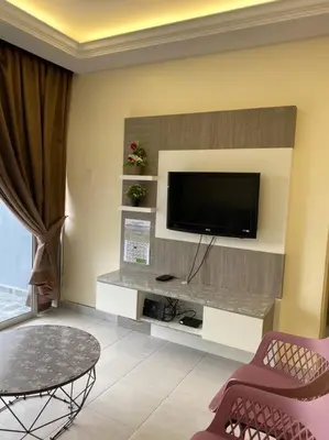 a living room with a flat screen tv on a wall at Emerald Avenue Apartment Madam Ng. in Cameron Highlands