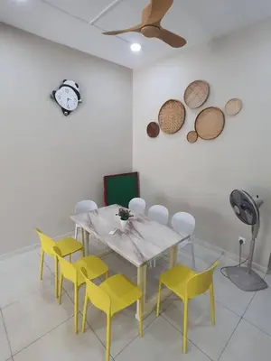 a dining room with a table and yellow chairs at 75 pangkor ocean in Pangkor