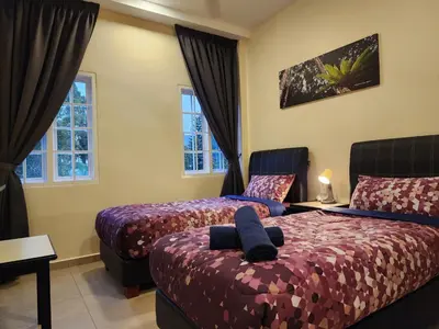 a hotel room with two beds and two windows at Fathers Guesthouse Age 7 years old and above only in Tanah Rata