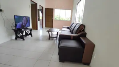 a living room with a couch and a tv at Pusing Holiday Apartment in Pusing