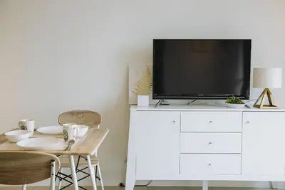 a living room with a tv on a white dresser at The WHITE, 2BR Cityview by WStay @ Tropicana 218 Macalister in George Town