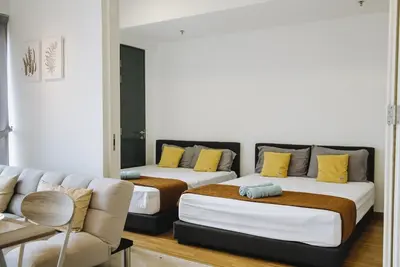 two beds in a room with a couch at The WHITE, 2BR Cityview by WStay @ Tropicana 218 Macalister in George Town