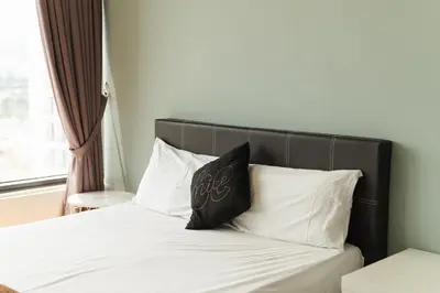 a bed with a black headboard and white pillows at The WILLOW, Studio Cityview by WStay @ Tropicana 218 Macalister in George Town
