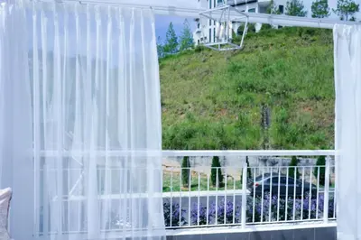 a window with a white curtain and a yard at Comfy Sofy 23- Balcony Garden (Night market) in Tanah Rata