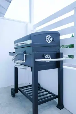 a blue grill sitting on a cart next to a window at Comfy Sofy 23- Balcony Garden (Night market) in Tanah Rata